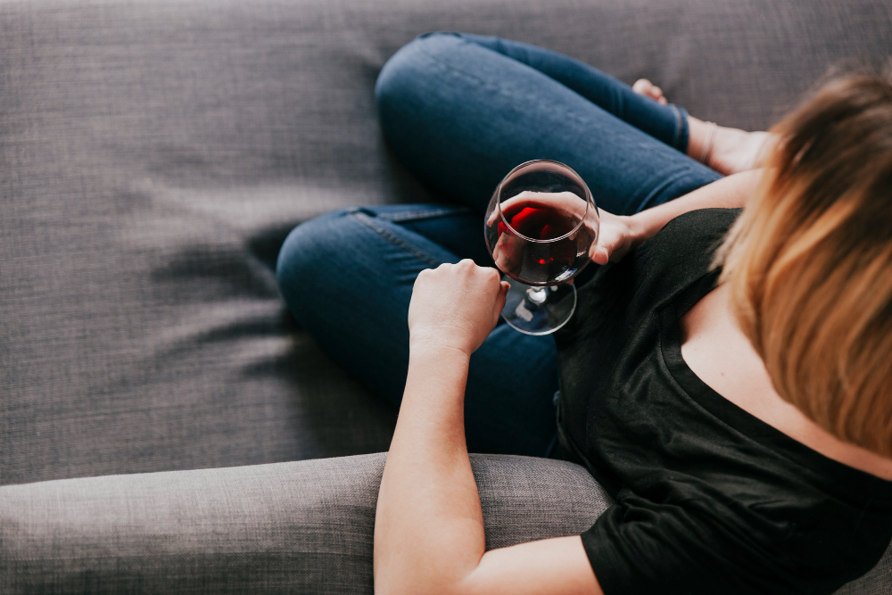 Mujer en el sofá con copa de vino