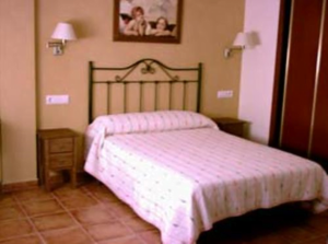 Alojamiento en los Mongros. Imagen de una habiatación con una cama grande y sábanas blancas.