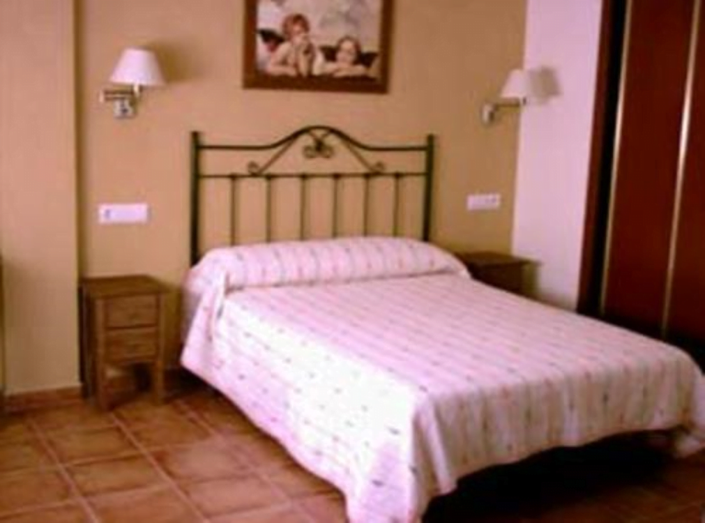 Alojamiento en los Mongros. Imagen de una habiatación con una cama grande y sábanas blancas.